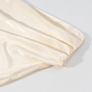 Detailaufnahme des glänzenden Satinstoffs und der eleganten Faltenstruktur dieser Jacke