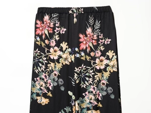 Close-up of elastic waistband on black trousers with colorful vintage floral pattern