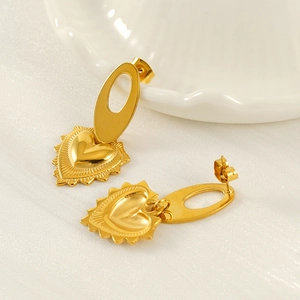Vintage golden stainless steel heart earrings with radiant texture on white silk background