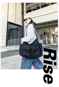 Detailed view of black canvas crossbody bag with large utility pockets in urban style
