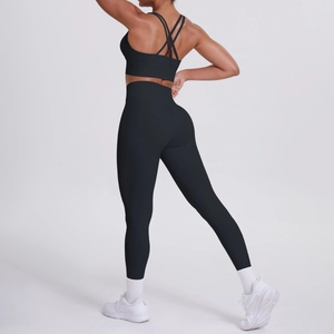 Dettaglio del reggiseno sportivo nero con incrocio e leggings yoga coordinati