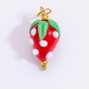 Macro detail of red strawberry pendant with green leaves and 18k gold plated ring