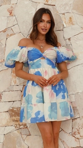 Détail de robe fleurie à col en V avec manches bouffantes et taille ajourée élégante