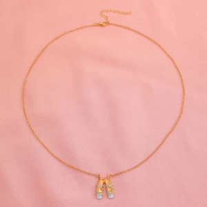 Elegant ballet slippers necklace with sparkling crystals on soft pink fabric background