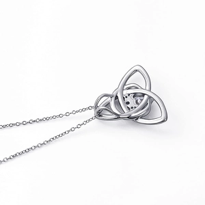 Macro side view of silver Celtic Trinity knot pendant with a round clear gemstone