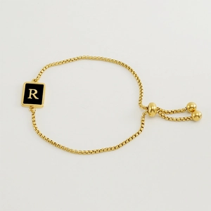 Détail du bracelet chaîne gourmette plaqué or 18K avec pendentif carré noir et lettre R dorée