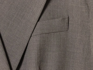 Detail shot of the woven texture and lapel stitching on the dark grey business suit set