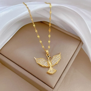 Titanium steel bird necklace with full diamonds on beige jewelry box with silk background