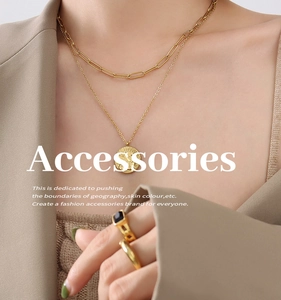 Close-up of layered 18K gold-plated angel coin necklaces and minimalist ring sets