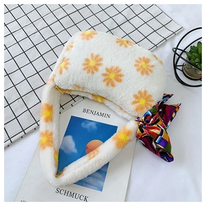 Detail of plush white faux fur shoulder bag with daisy floral pattern and silk scarf