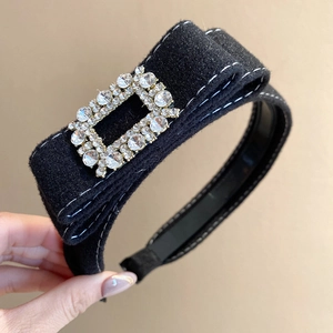 Detail view of the velvet headband featuring a luxury square rhinestone buckle and bow