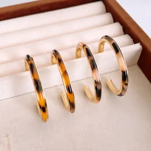 Set di quattro orecchini a cerchio a C in resina con stampa leopardata e metallo oro