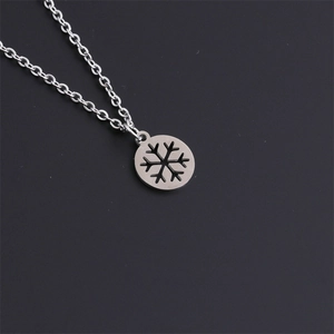 Close-up of a silver snowflake cutout pendant on a cable chain necklace