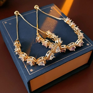 Detail of adjustable gold double heart bracelets with pink and clear zircon stones