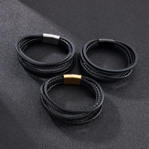 Detail of multi-layer braided leather bracelets with silver, black, and gold magnetic clasps