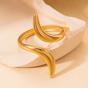 Gros plan d'une bague serpent dorée au fini mat sur un support en pierre minimaliste
