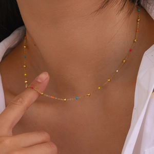 Bohemian gold stainless steel necklace with small colorful beads on a model's neck