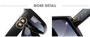 Close-up of oversized sunglasses showing gold metal hinge and side logo decoration