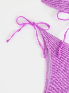 Detail of purple smocked bikini fabric featuring adjustable side-tie bow design