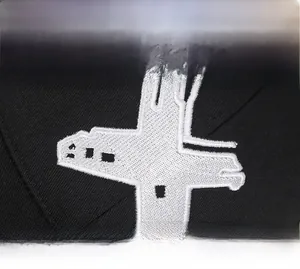 Close-up of high-quality black fabric texture with detailed white embroidery on baseball cap