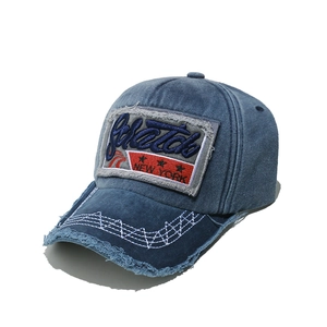 Detail of vintage denim baseball cap with 3D embroidery patch and distressed frayed edges