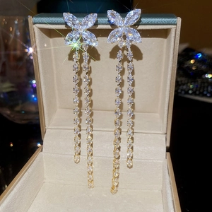 Detailed view of champagne gold butterfly tassel earrings with sparkling zircon stones