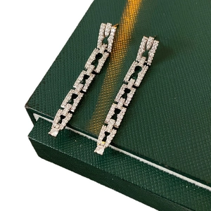 Silver chain dangle earrings with cubic zirconia crystals on dark green jewelry box