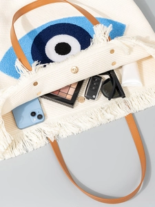 Bohemian woven tote bag with blue evil eye embroidery and brown leather shoulder straps