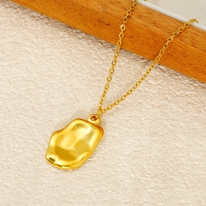 Irregular liquid metal gold pendant necklace with a textured lava design on a stone base