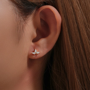 Close-up of golden marquise zircon butterfly stud earring worn on model ear