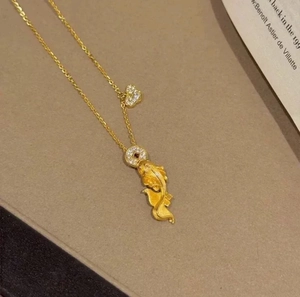Detail of 24k gold koi fish pendant with heart charm and sparkling zircon stones