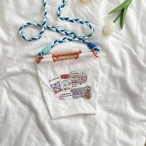 Détail du mini sac en toile blanche avec graffitis colorés et anse en corde tressée