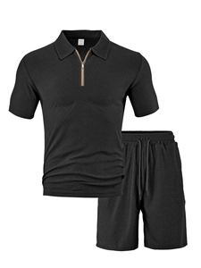 Flat lay of black men's two-piece polo set showing textured honeycomb fabric and zipper