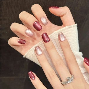 Burgundy cat eye press-on nails set with champagne glitter and rhinestone accents