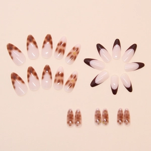 Detail of almond-shaped fake nails with brown tortoise pattern and gold micro-beads