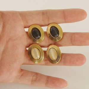 Boucles d'oreilles en acier inoxydable doré avec pierres ovales noires et blanc crème