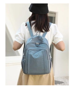 Detail of blue nylon backpack featuring metal hardware and Colorful Fox brand logo