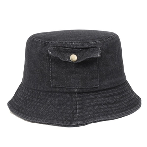 Detailed view of black washed denim bucket hat featuring a small front pocket with metal snap