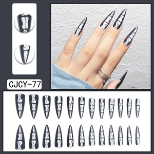 Gothic stiletto press-on nails with black background and white skull patterns