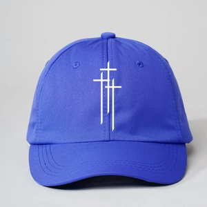 Detail of royal blue baseball cap featuring white cross print and stitched canvas texture
