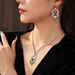 Détail d'une parure bijoux luxe vert émeraude portée par un mannequin sous lumière douce