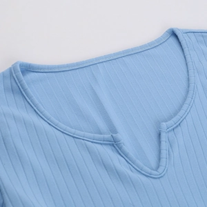 Gros plan sur le tricot côtelé bleu clair montrant les détails de l'encolure en V