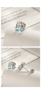 Macro shot of titanium steel crab stud earrings with light blue faceted gemstones