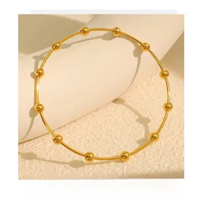 Detailed close-up of a minimalist gold beaded stainless steel bangle for women