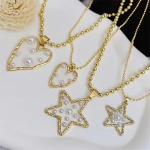 Elegante Perlenhalsketten mit Herz- und Sternanhängern auf weißem minimalistischem Display