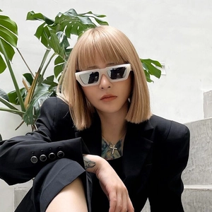 Detail view of small square cream sunglasses with silver mirror lenses on model