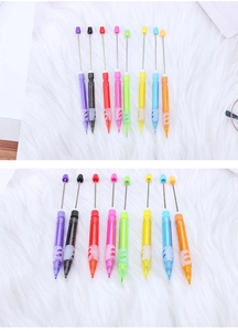 Detailed view of eight colorful beadable mechanical pencils on soft white faux fur