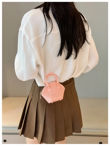 Pink jelly mini shell bag with woven texture and gold chain strap on model back