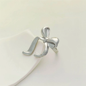 Minimalist silver bow-shaped stainless steel open ring with a matte metallic finish