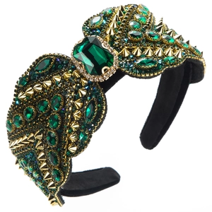 Détail des cristaux verts et des pointes dorées sur le serre-tête style baroque